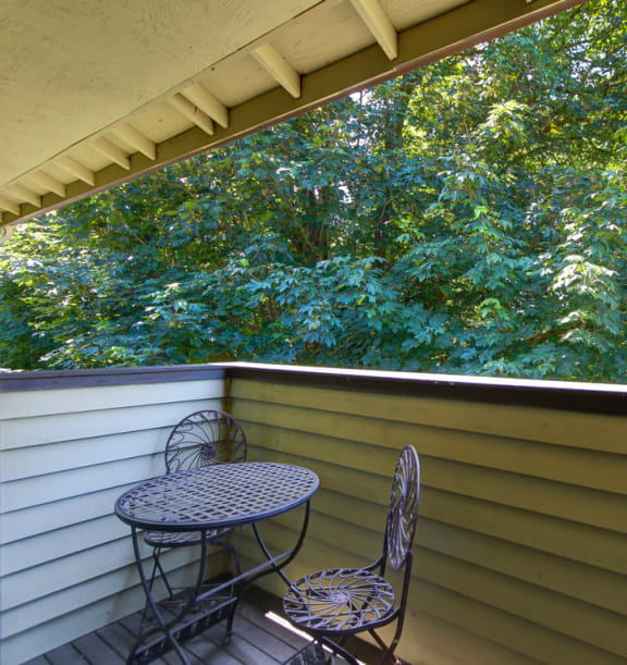 a balcony with two chairs and a table
